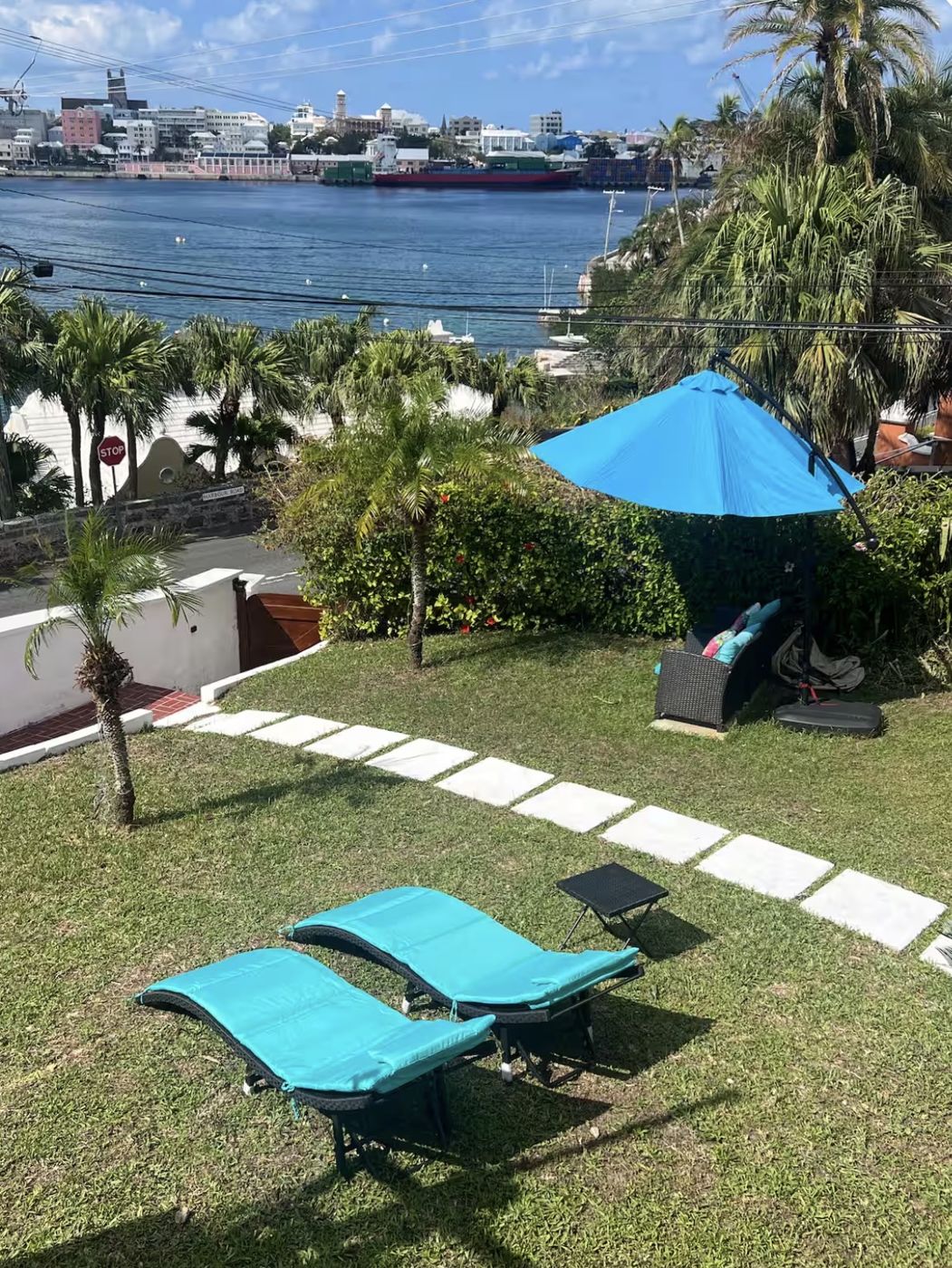 Garden with turquoise loungers and a blue umbrella overlooking Hamilton Harbour and the city skyline