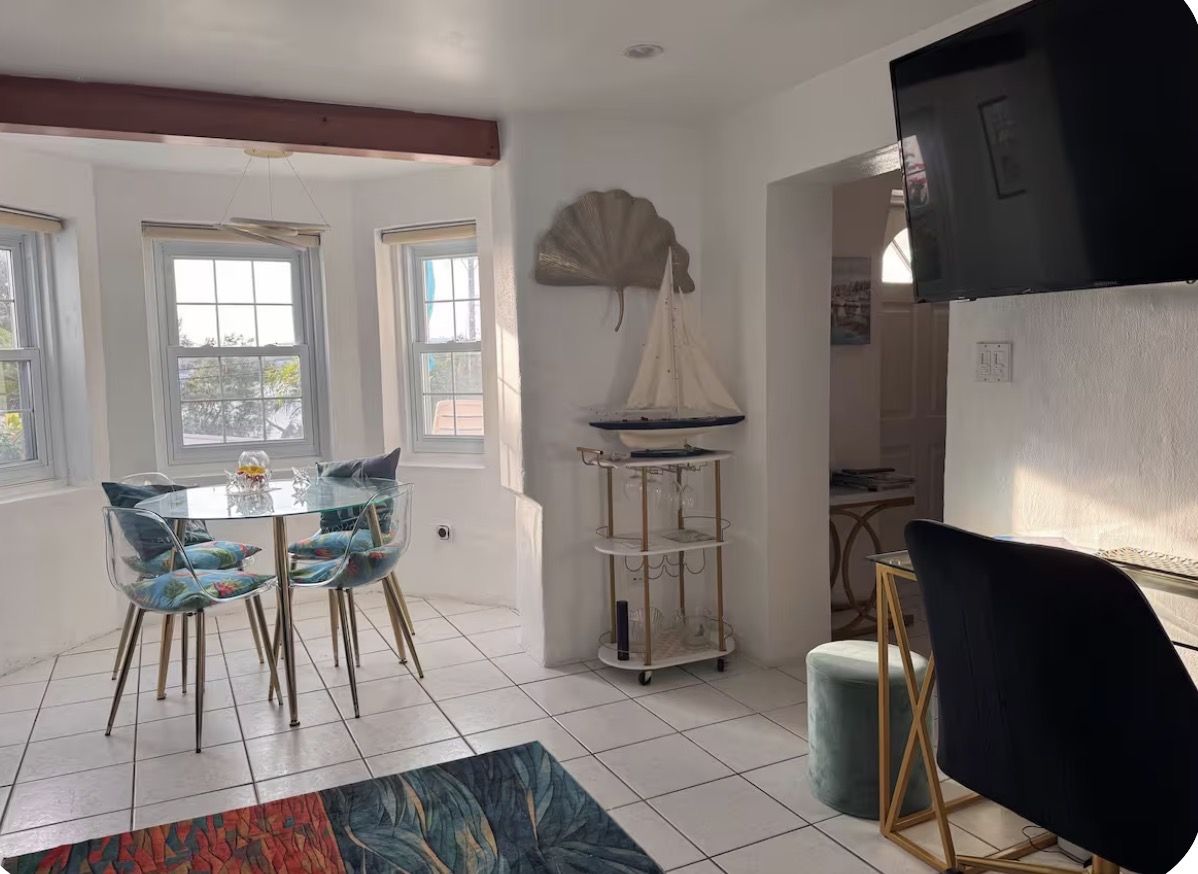 Living area with dining bay, bar cart and wall-mounted TV